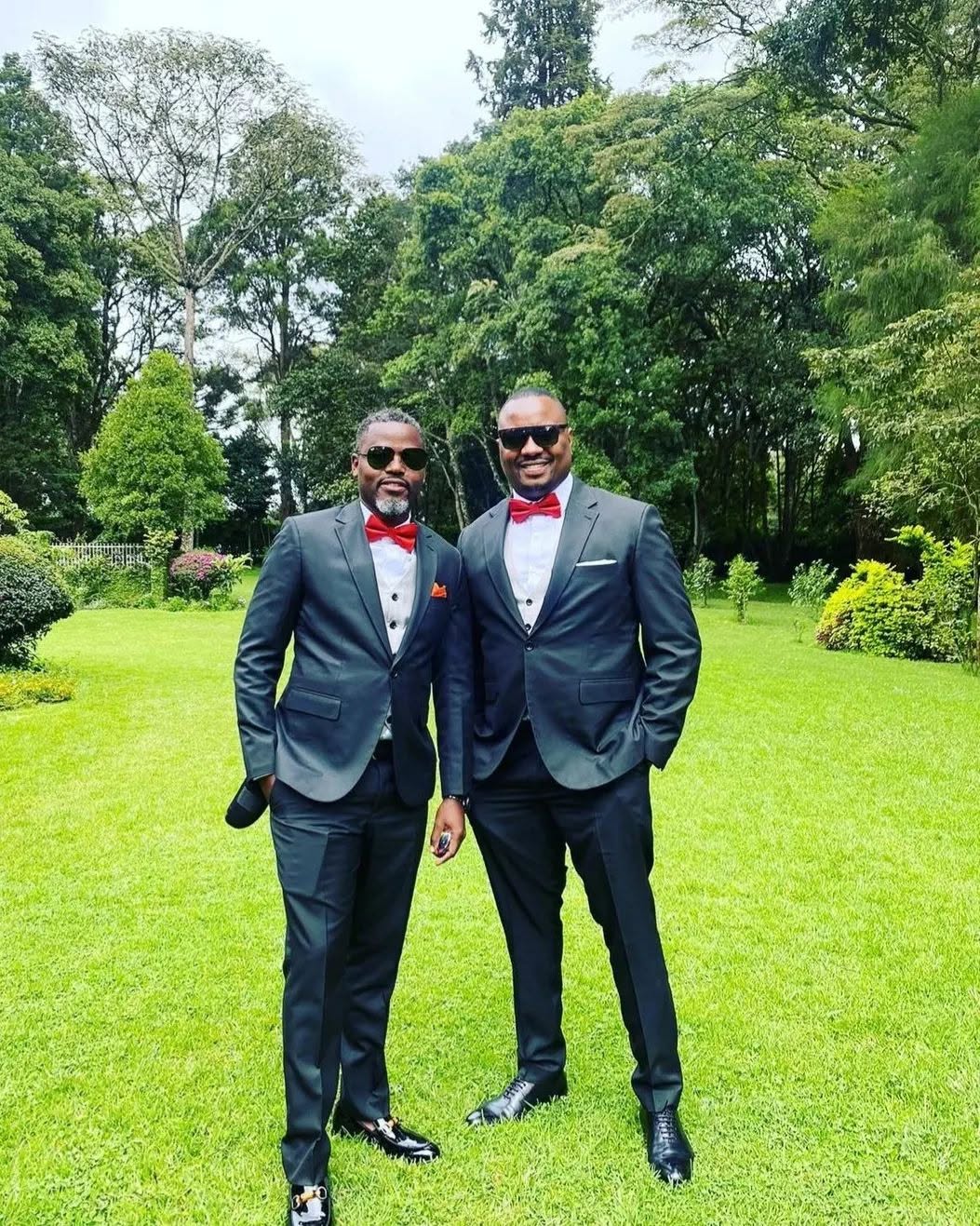 Two clients in black suits with red bow ties